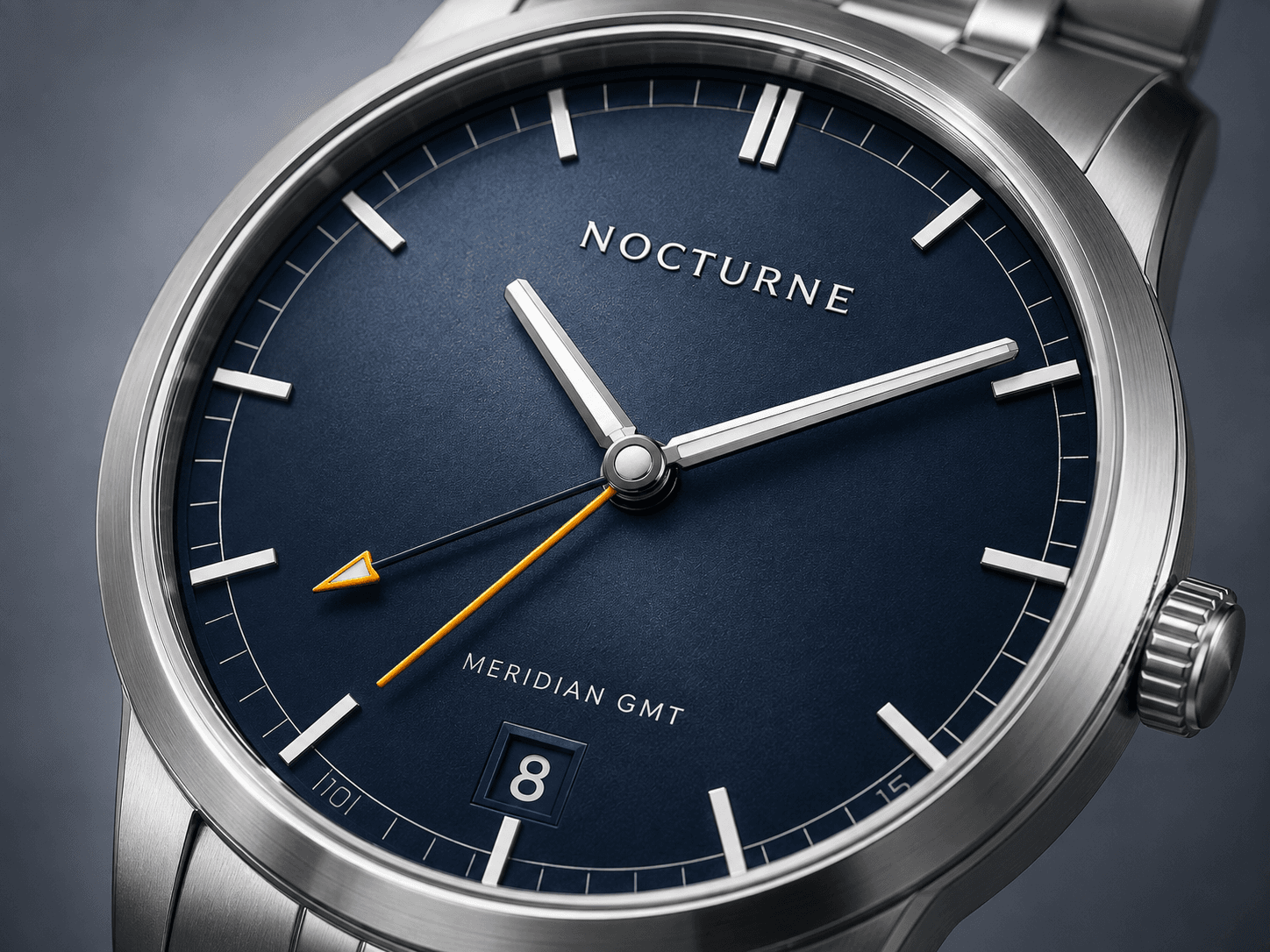 Close detail of the Meridian GMT slate-blue dial and orange GMT hand