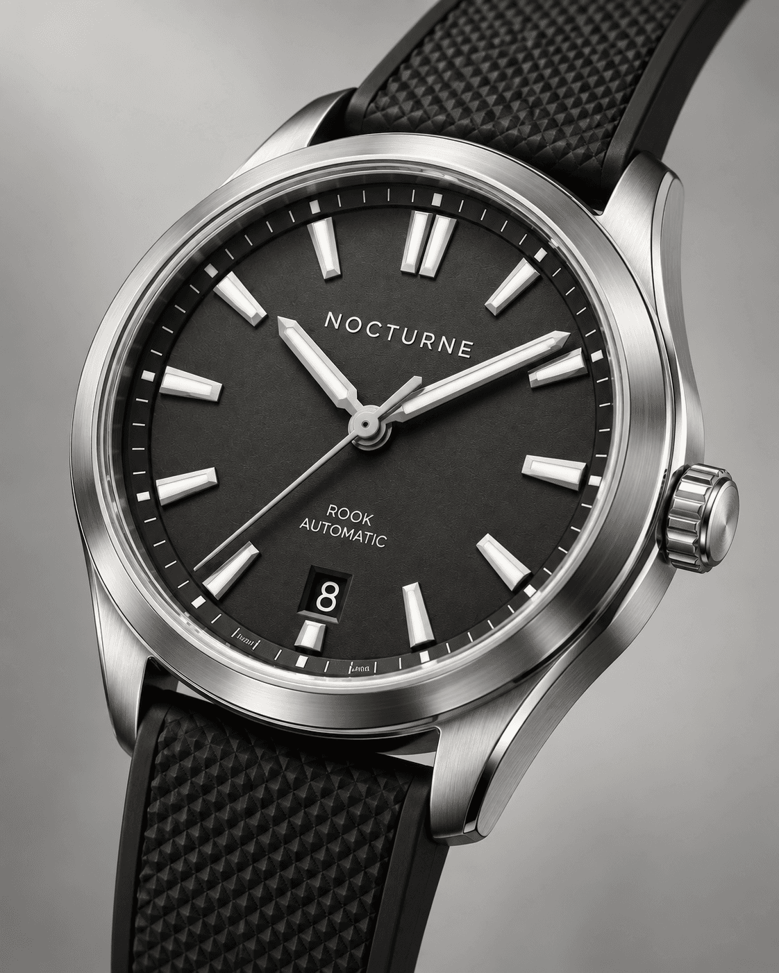 Close-up of the Rook Automatic graphite dial, steel case, crown, and textured rubber strap